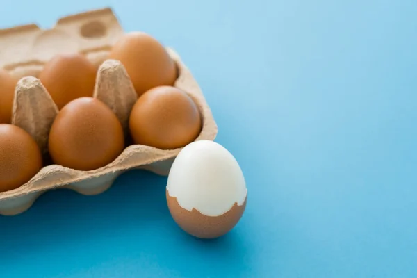 Œufs Cuits Crus Coquilles Près Carton Sur Fond Bleu — Photo