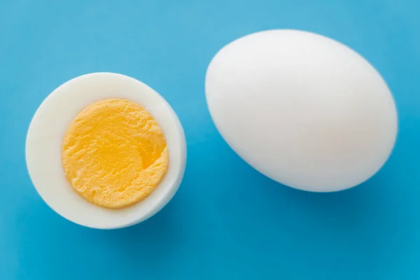 Mavi Arka Planda Yumurta Sarısı Olan Doğal Haşlanmış Yumurtanın Üst — Stok fotoğraf