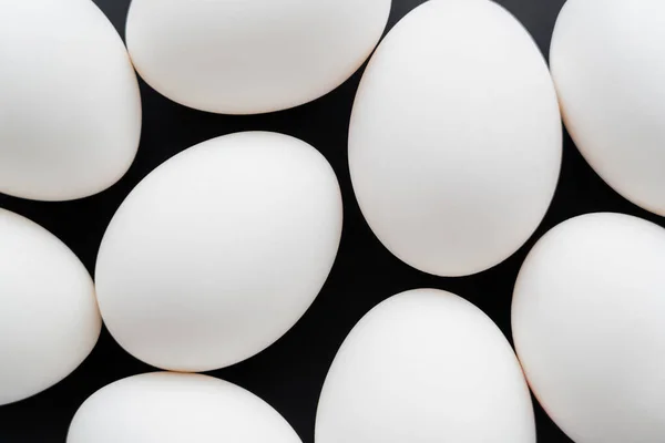 用黑色隔离开的白色鸡蛋的顶部视图 — 图库照片