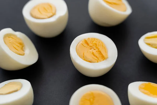 Close up view of boiled eggs with yolks on black background