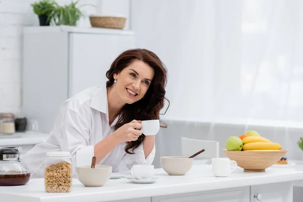 Bruna Donna Camicia Possesso Tazza Caffè Vicino Colazione Frutta Cucina — Foto Stock