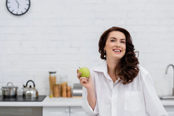 Χαμογελαστή Γυναίκα Πουκάμισο Κρατώντας Φρέσκο Μήλο Στην Κουζίνα — Φωτογραφία Αρχείου