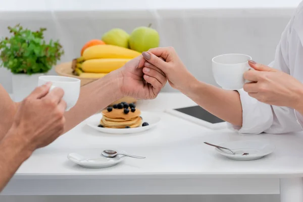 Vista Recortada Pareja Cogida Mano Café Cerca Del Desayuno Cocina — Foto de Stock