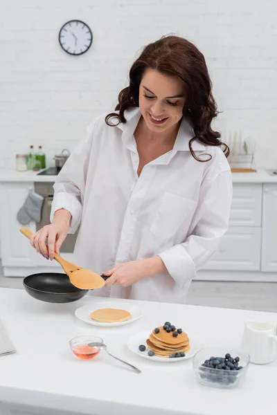 Lächelnde Frau Hemd Kocht Pfannkuchen Neben Blaubeeren Der Küche — Stockfoto