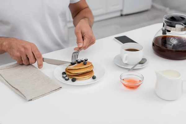 Cropped View Man Cutting Pancakes Coffee Smartphone Kitchen — Stock Photo, Image