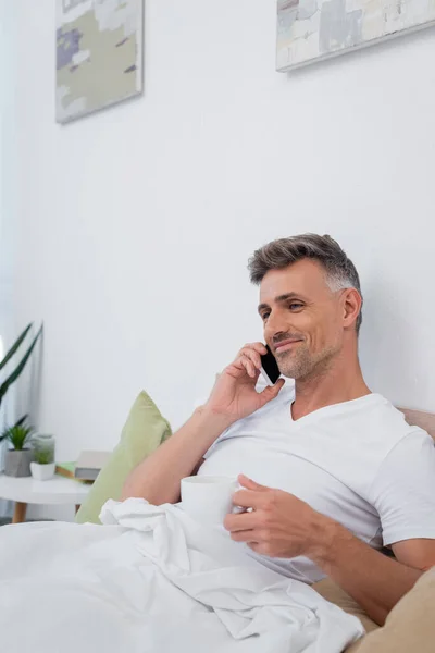 Smiling Man Talking Cellphone Holding Cup Coffee Bed Home — Stock Photo, Image