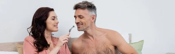 Glimlachende Vrouw Met Bosbessen Vork Terwijl Shirtloze Man Bed Voedt — Stockfoto