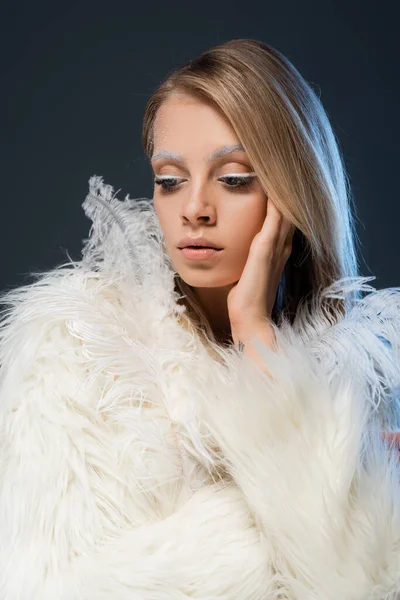 白い化粧をした可愛い若い女性がフェイクファーのジャケットと羽に身を潜めて — ストック写真