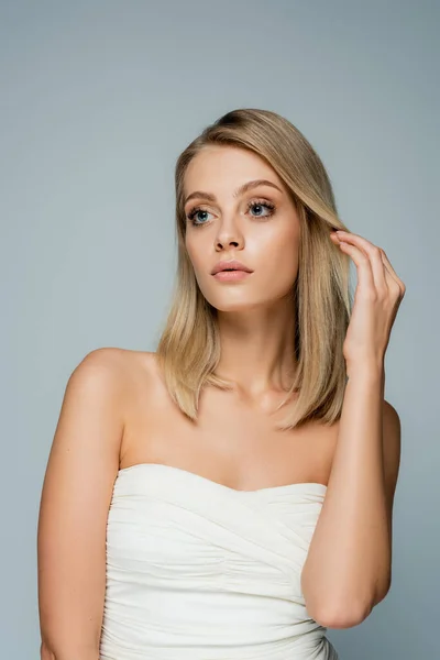 Mujer Joven Con Hombros Desnudos Maquillaje Natural Ajustando Pelo Rubio — Foto de Stock
