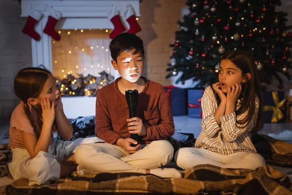 Chico Asiático Con Linterna Hablando Cerca Niños Asustados Durante Celebración — Foto de Stock