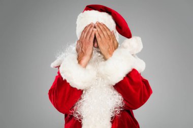 Sakallı Noel Baba kostümlü, yüzünü gri renkte kapatıyor. 