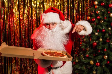 Father christmas pointing at takeaway pizza in box near festive tinsel  clipart
