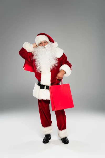 Full Length Santa Claus Costume Holding Purchases Grey Background — Stock Photo, Image