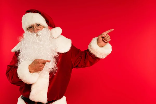 Santa Claus Brýlích Ukazuje Prsty Dívá Fotoaparát Izolované Červené — Stock fotografie