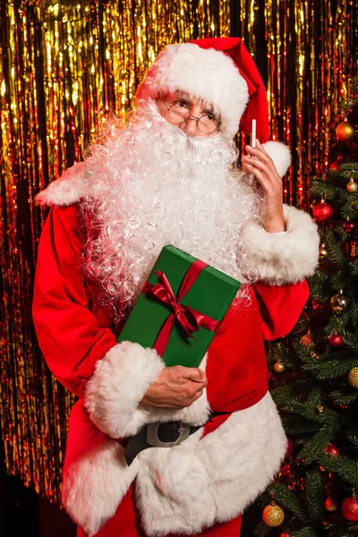 Papai Noel Segurando Smartphone Presente Perto Árvore Natal Decorada Ouropel — Fotografia de Stock