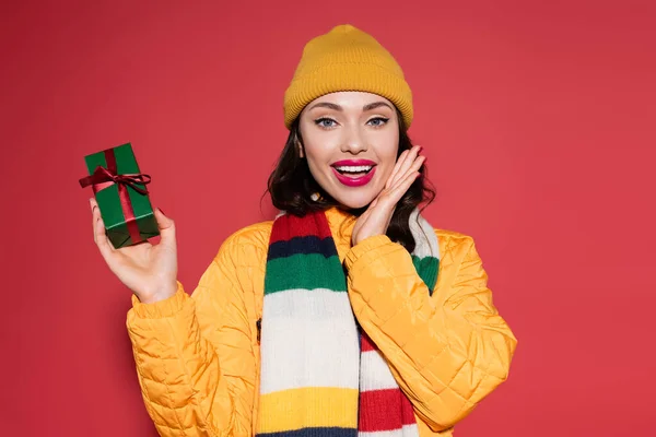 Verbaasd Jonge Vrouw Beanie Hoed Gestreepte Sjaal Bedrijf Verpakt Geschenk — Stockfoto