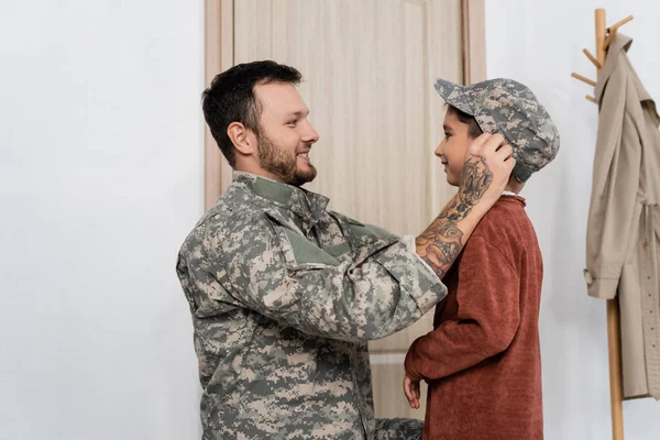 Visão Lateral Homem Barbudo Colocando Tampa Militar Filho Alegre Encontrá — Fotografia de Stock