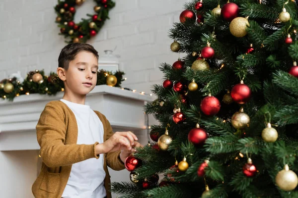 Fiú Díszítő Zöld Fenyő Karácsonyi Labdák Nappaliban Otthon — Stock Fotó