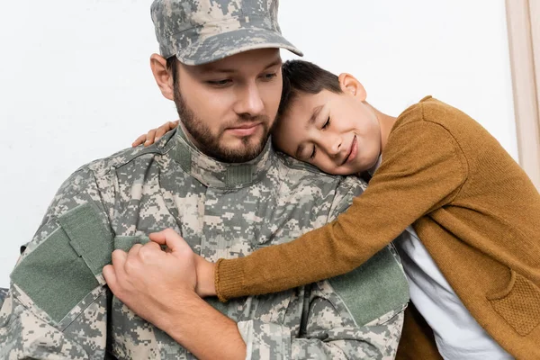 Mosolygós Gyerek Csukott Szemmel Öleli Apát Katonai Egyenruhában Miközben Otthon — Stock Fotó