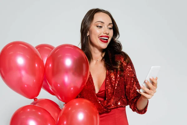 Vrolijke Stijlvolle Vrouw Met Ballonnen Het Gebruik Van Mobiele Telefoon — Stockfoto