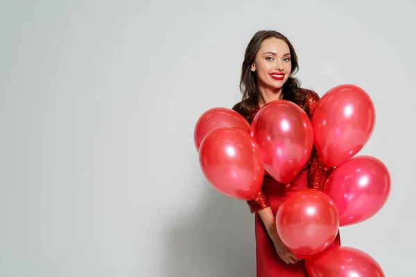 Cheerful Brunette Woman Dress Holding Red Balloons Grey Background — Stock Photo, Image