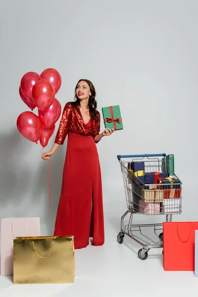 Cheerful Elegant Woman Holding Balloons Present Shopping Cart Bags Grey — Stock Photo, Image