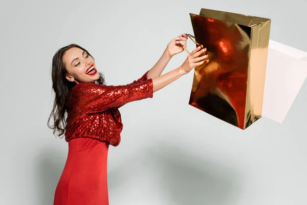 Glückliche Brünette Frau Roten Kleid Mit Einkäufen Auf Grauem Hintergrund — Stockfoto