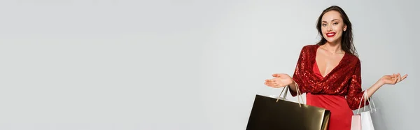 Positive Woman Red Dress Holding Shopping Bags Isolated Grey Copy — Stock Photo, Image