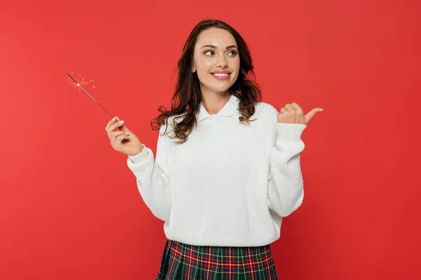 Smiling Brunette Woman Sweater Holding Sparkler Pointing Finger Isolated Red — Stock Photo, Image