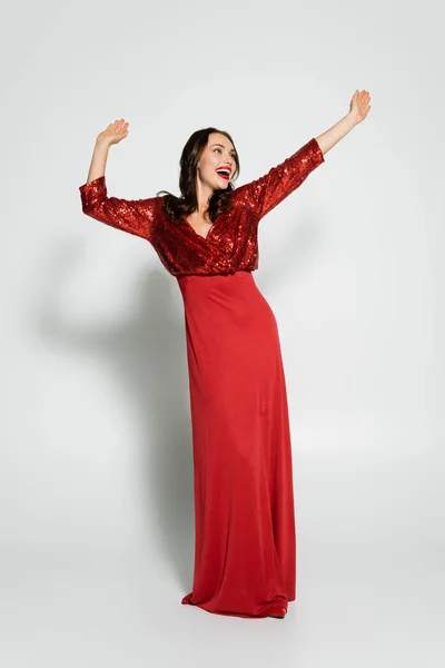 Красивая Брюнетка Элегантном Красном Платье Танцует Сером Фоне — стоковое фото