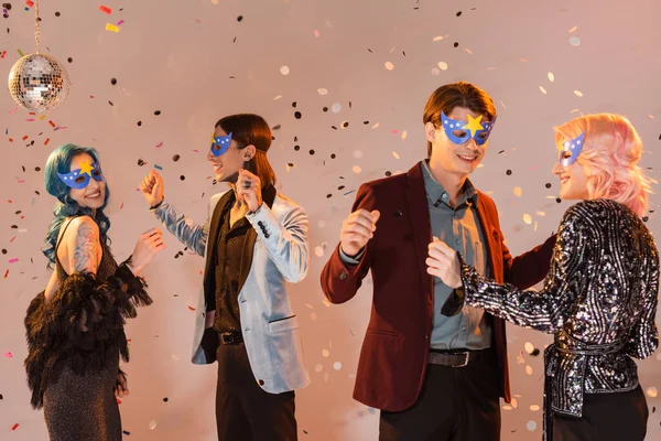 Trendiga Queer Vänner Fest Masker Dansar Fallande Konfetti Samtidigt Fira — Stockfoto