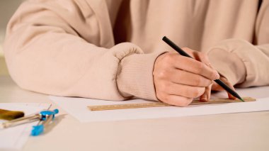 Evde cetvel ve kalemle çizim yapan kadın manzarası 