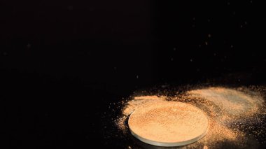 Siyah arkaplandaki bej yüz pudrasının fotokopi alanı ile görüntüsünü kapat