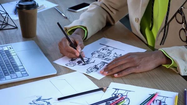 非洲裔美国设计师在笔记本电脑和咖啡店附近画草图的剪影 — 图库照片