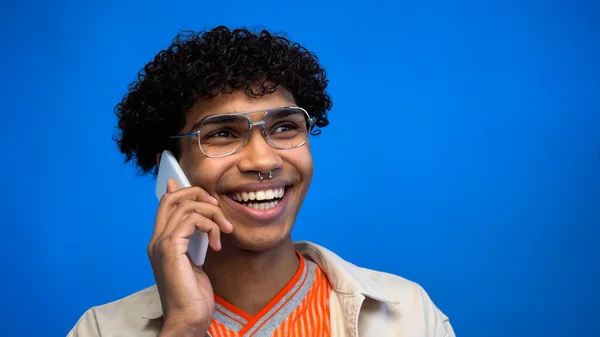 기쁨에 넘치는 아프리카 미국인 안경쓴 남자푸른 색으로 고립된 핸드폰으로 얘기하고 — 스톡 사진