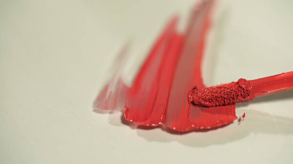 Close up view of applicator and lip gloss on grey background 