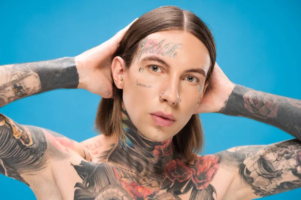 Młody Przekłuty Mężczyzna Tatuażami Patrząc Obiektyw Podczas Pozowania Niebiesko — Zdjęcie stockowe