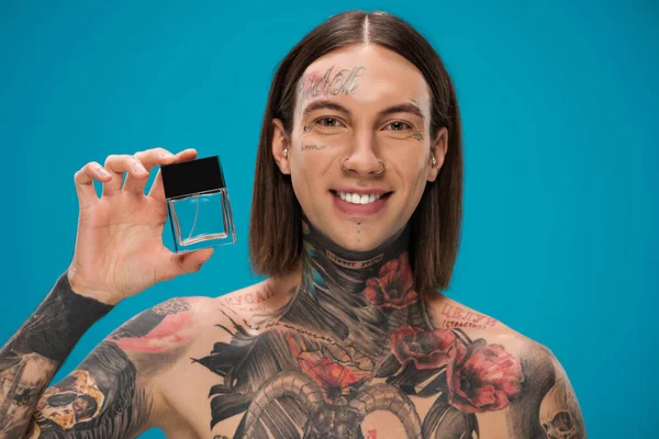 Homem Feliz Tatuado Segurando Garrafa Com Perfume Isolado Azul — Fotografia de Stock