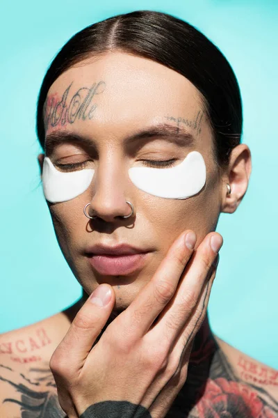 Close Tattooed Young Man Closed Eyes Eye Patches Isolated Turquoise — Stock Photo, Image