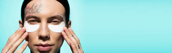Close Tattooed Young Man Adjusting Eye Patches Looking Camera Isolated — Stock Photo, Image
