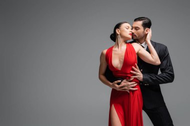 Gri üzerinde fotokopi alanı olan zarif bir çift tango yapıyor.