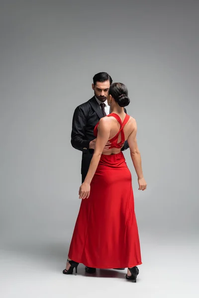 Bailarina Traje Abrazando Morena Pareja Vestido Rojo Sobre Fondo Gris — Foto de Stock