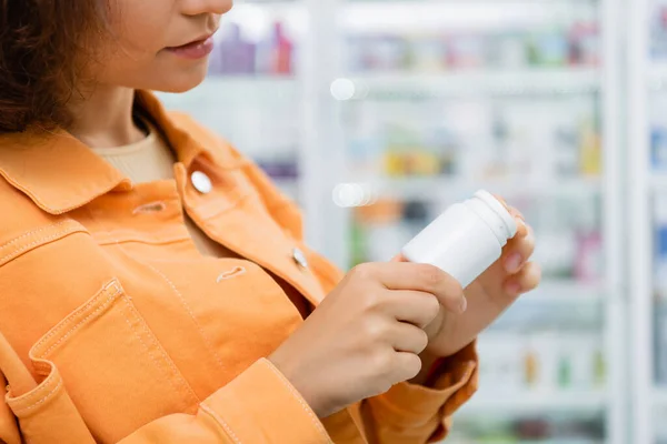 Vista ritagliata della bottiglia di donna con farmaci in farmacia — Foto stock