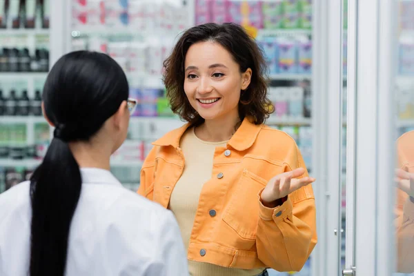 Веселий жест клієнта під час розмови з фахівцем в аптеці — стокове фото