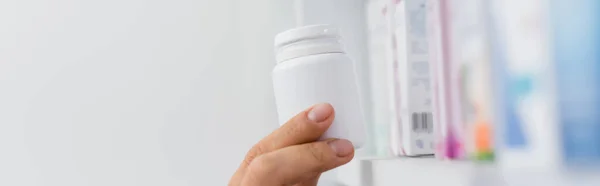 Cropped view of pharmacist taking bottle with medication, banner — Stock Photo