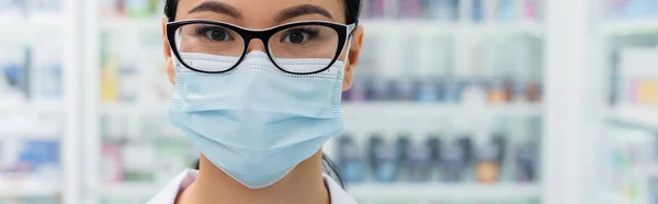 Farmacéutico asiático en gafas y máscara médica, bandera - foto de stock