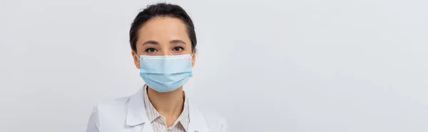 Médico em casaco branco e máscara médica olhando para a câmera, banner — Fotografia de Stock