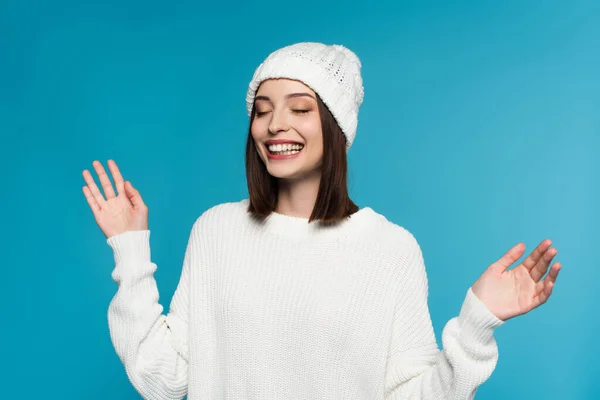 Cheerful woman in warm sweater and hat isolated on blue — Stock Photo