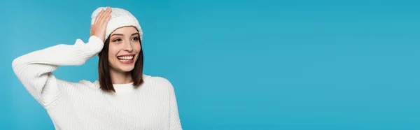 Mujer bonita en sombrero de punto sonriendo aislado en azul, bandera - foto de stock