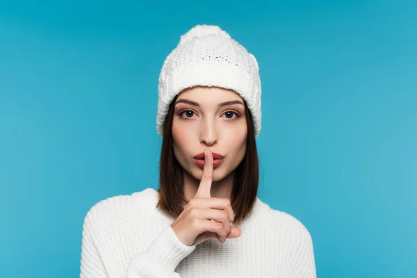 Giovane donna in cappello mostrando gesto segreto isolato su blu — Foto stock